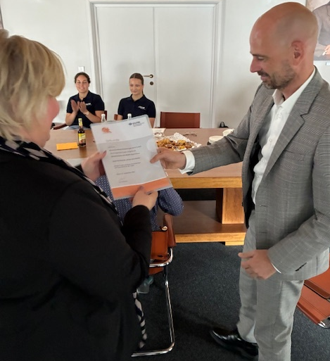 Ute Emsel, Auditorin der BGHM, überreicht Heiko Maier, Vorstand, die Siegerurkunde.